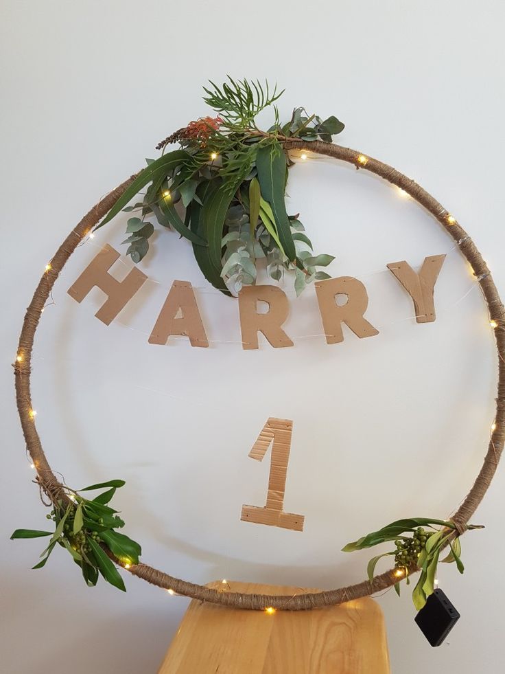 a wooden sign that says harry on it with plants in the middle and lights around it