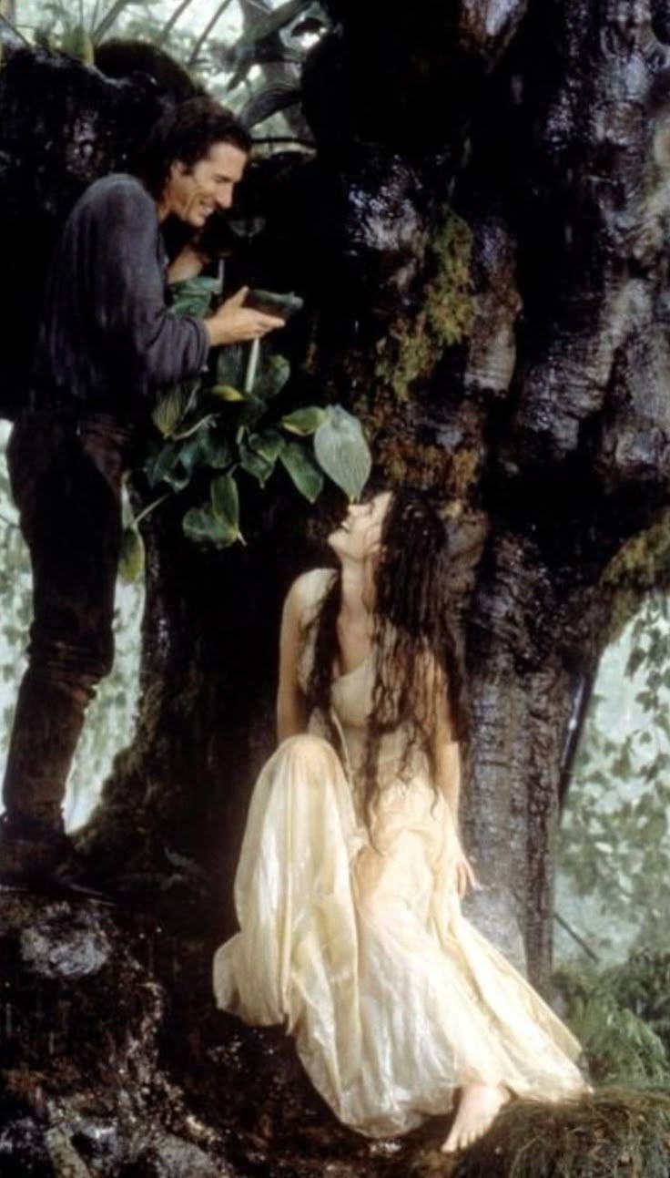 a man standing next to a woman near a tree