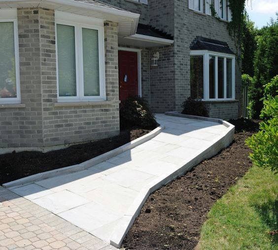 a brick house with landscaping around the front door and walkway leading up to the entrance