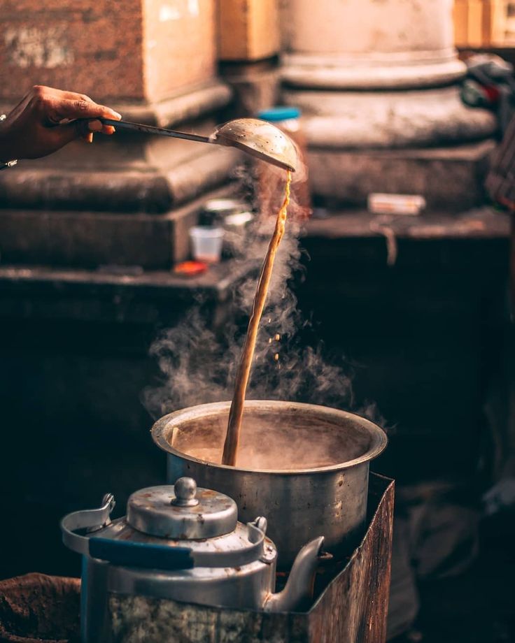 a person stirring something in a pot on top of a stove with steam coming from it