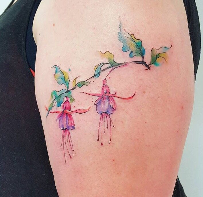 a woman's shoulder with flowers and leaves painted on the back of her arm