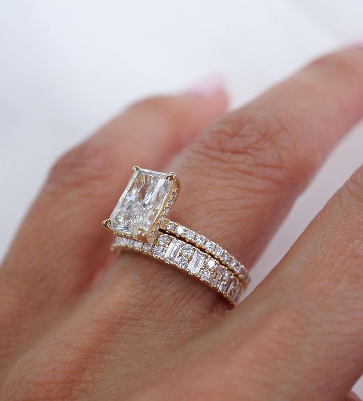 a woman's hand with an engagement ring and wedding band