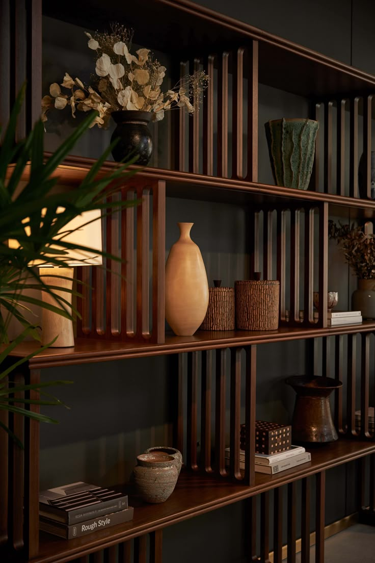 a book shelf with vases and other items on it