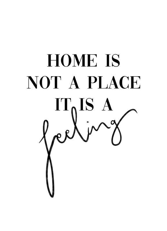 the words home is not a place it is a feeling in black ink on a white background