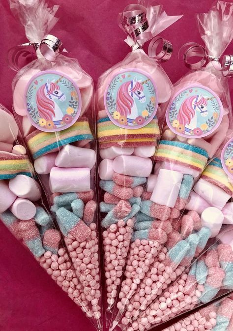 a bunch of pink and blue candies with unicorns on them sitting next to each other