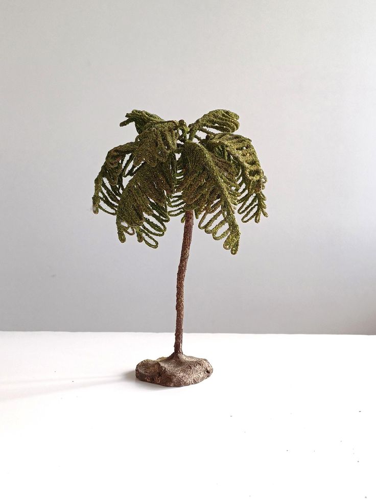 a small palm tree sitting on top of a white table