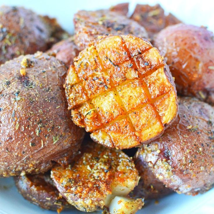 a white plate topped with potatoes covered in seasoning