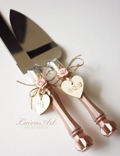 two heart shaped utensils tied with twine and pink roses are sitting next to each other