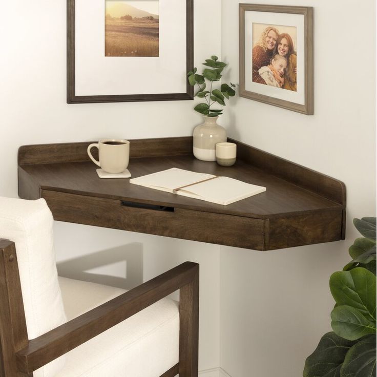 a corner desk with a coffee cup and pictures on the wall