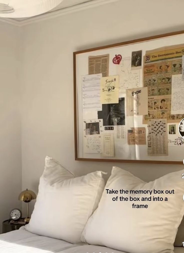 a bed with white pillows and pictures hanging on the wall above it that says take the memory box out of this bed into a frame