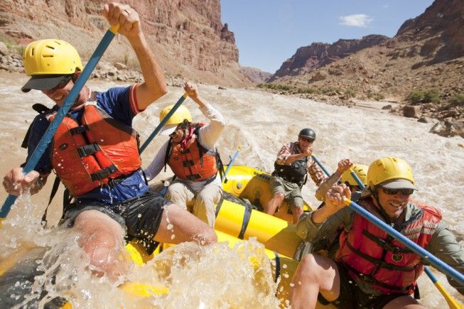 a group of people riding rafts down a river in the middle of canyons