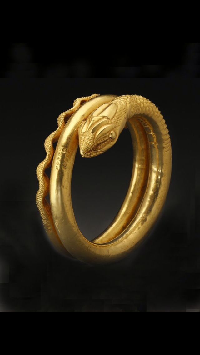 a gold snake ring on a black background