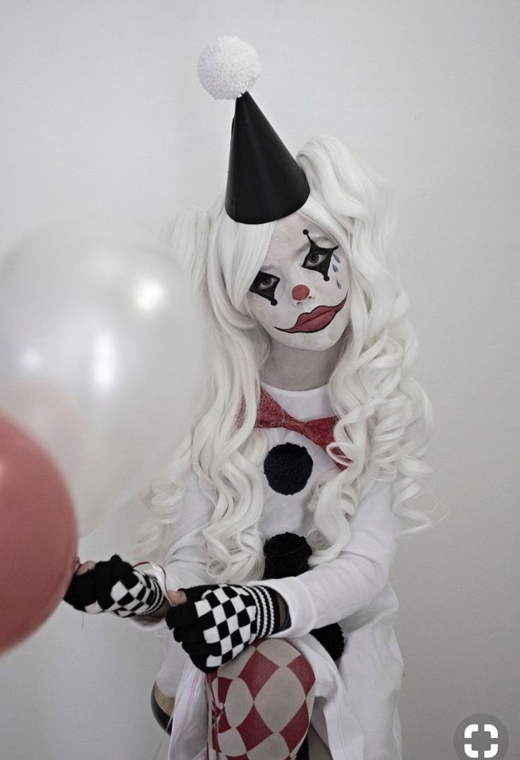 a woman dressed as a clown holding a balloon