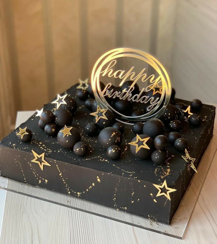 a black and gold birthday cake with stars on it