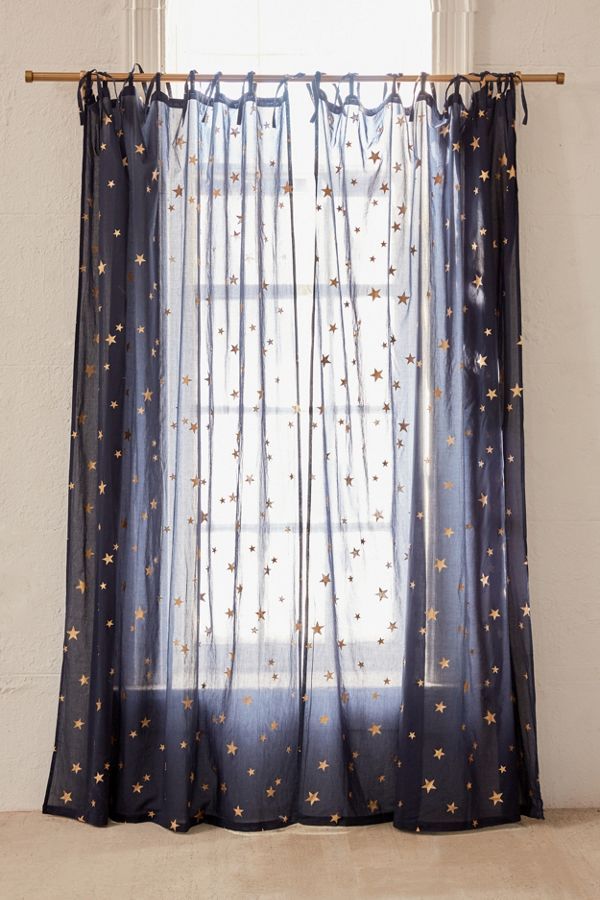 a curtain with gold stars on it in front of a white wall and window sill