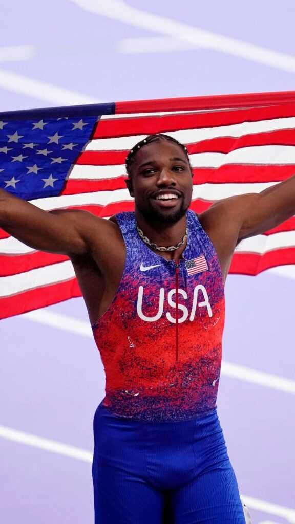 a man holding an american flag in front of his face and arms with both hands