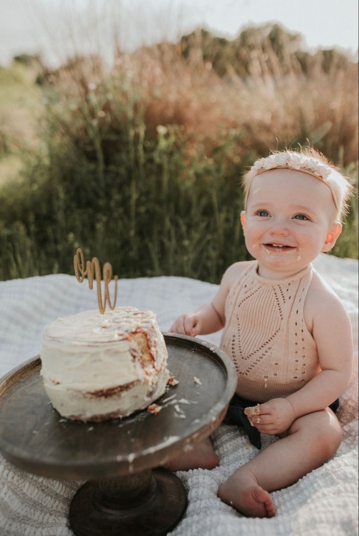 a baby sitting in front of a cake