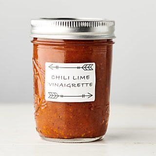 a jar of chili lime vinaigrette sits on a table with an arrow sticker