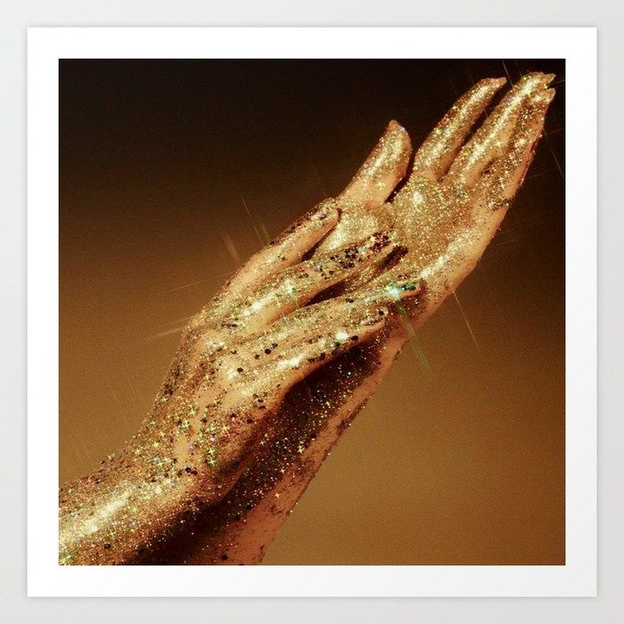 a woman's hand with gold glitter on it