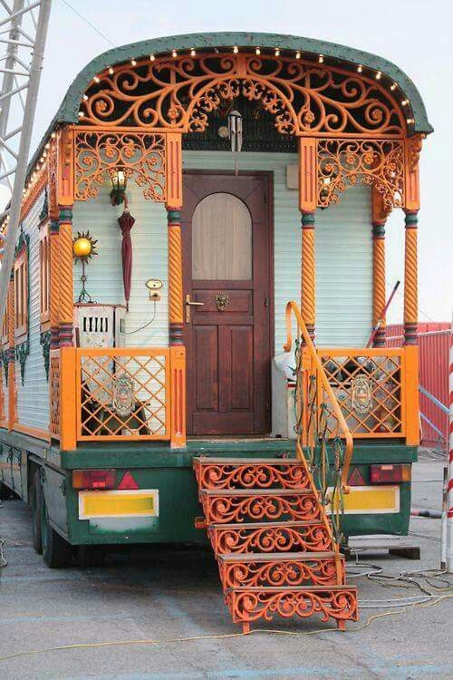 an orange and green train car with stairs leading up to it's front door