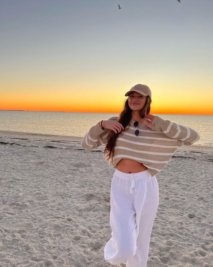 beach outfit, tan striped sweater, white beach pants Sunset Outfits Beach Comfy, Comfy Beach Outfit Winter, Covered Beach Outfit, Chilly Beach Day Outfit Casual, 60 Degree Beach Outfit, Cute Beach Outfits Cold Weather, Cold Beach Sunset Outfit, Fall Beach Bonfire Outfit, Beach Cleanup Outfit