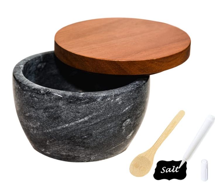 a wooden spoon sitting next to a black and white bowl