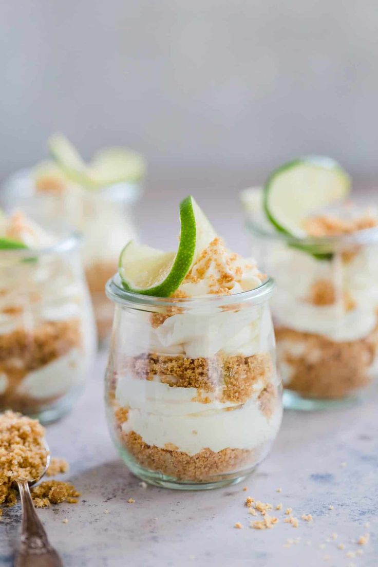 small glass jars filled with desserts on top of a table