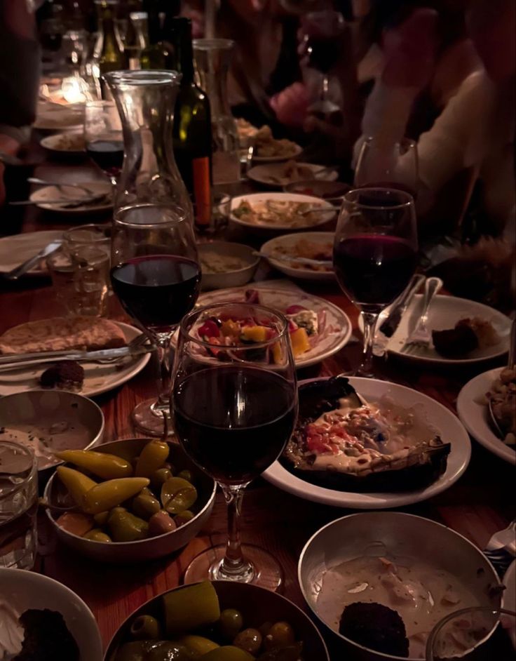 a table full of food and glasses of wine