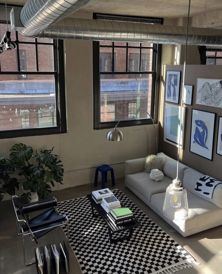 a living room filled with furniture and windows next to a black and white checkered rug