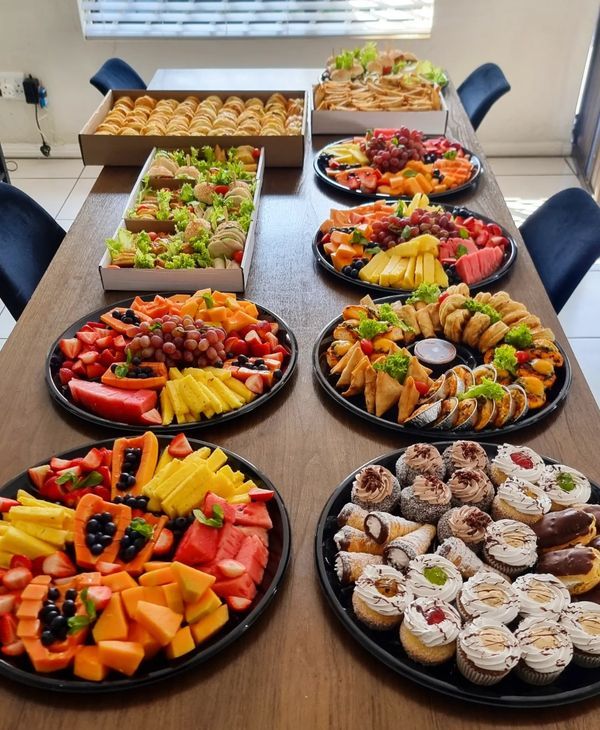 a table topped with plates filled with different types of food and desserts on top of it