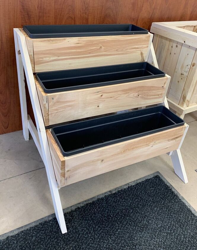 three planters are stacked on top of each other in front of a wooden wall