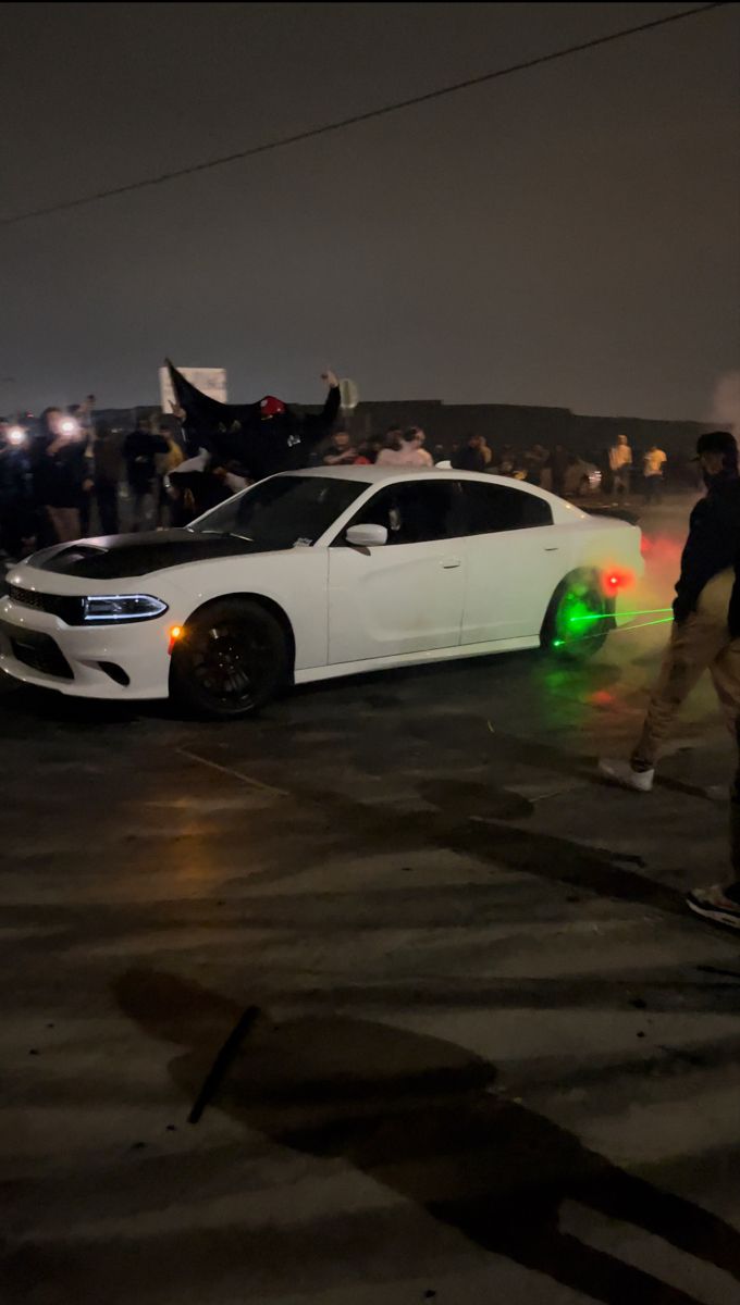 a white car parked in front of a group of people