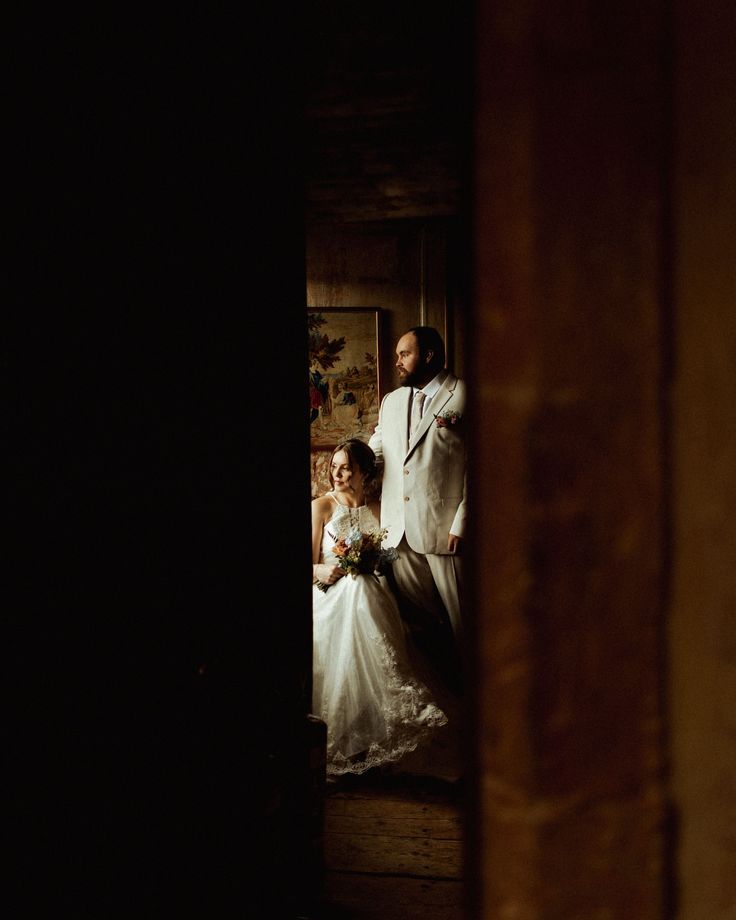 a bride and groom standing in the doorway