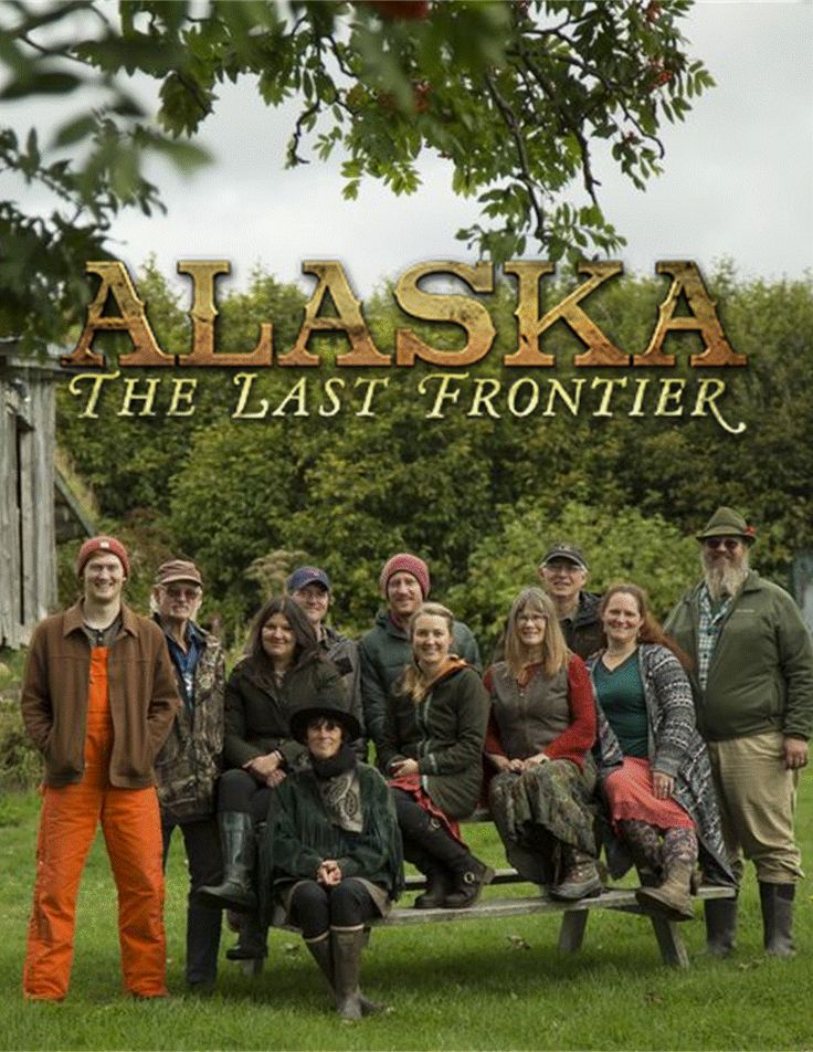 a group of people standing in front of a sign that says alaska the last frontier