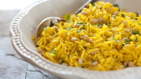 a white bowl filled with yellow rice and beans