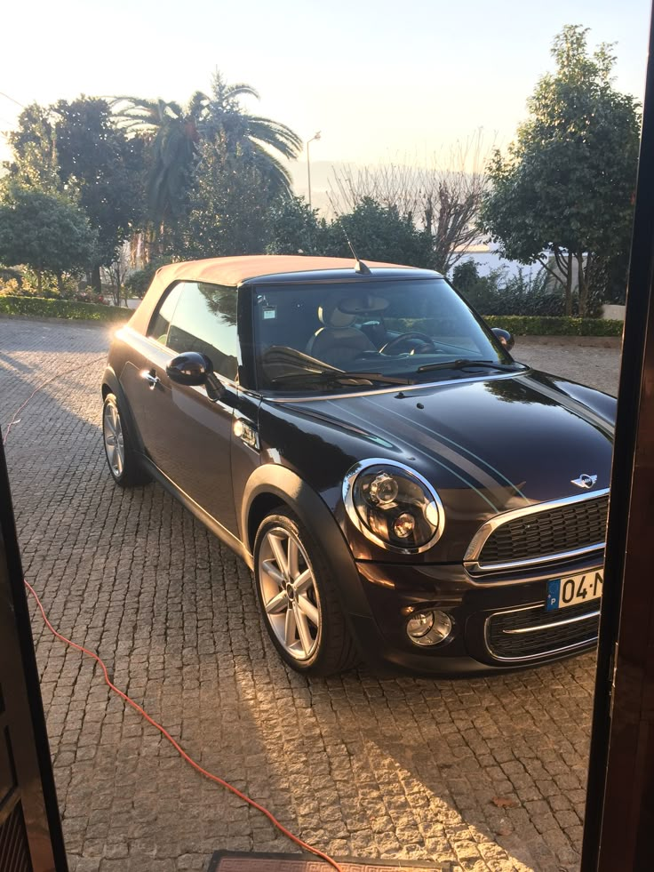 a small black car parked in front of a house