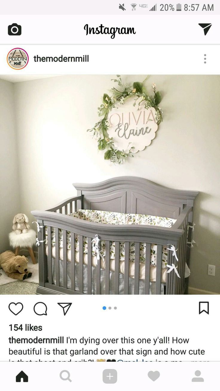 a baby crib in the corner of a room with a wreath on the wall