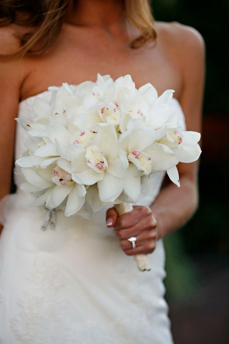 a bride holding a bouquet of white flowers