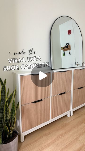 a white dresser sitting next to a mirror on top of a wooden cabinet with drawers