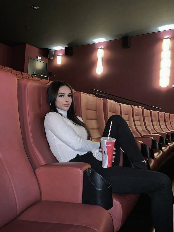 a woman is sitting in an empty theater