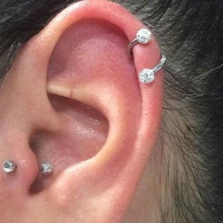 an ear with three piercings attached to it's middle part and two smaller ones on the other side