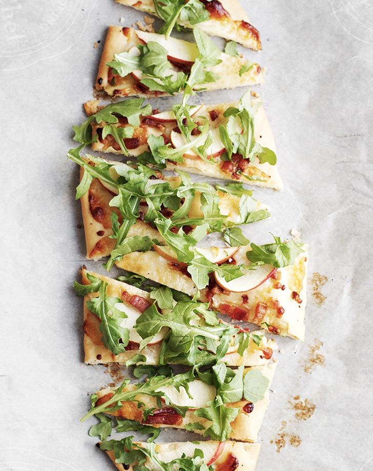 several slices of flatbread pizza topped with lettuce and cheese