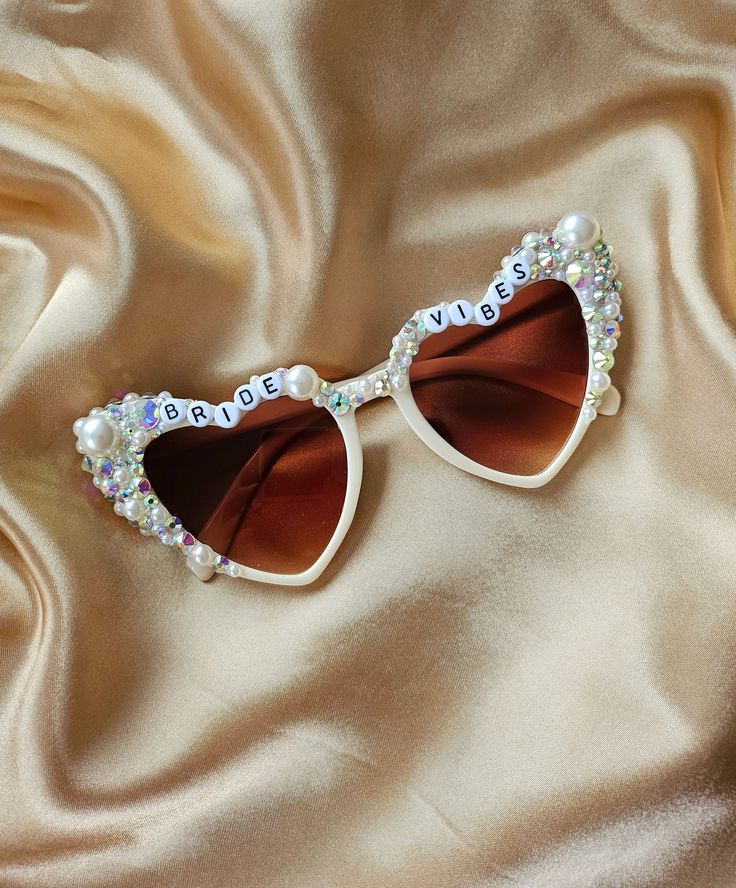 a pair of white sunglasses with pearls on the sides and bridal written on them