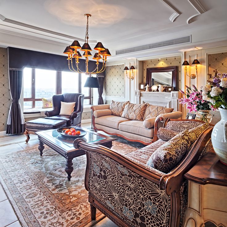 a living room with couches, chairs and a chandelier hanging from the ceiling