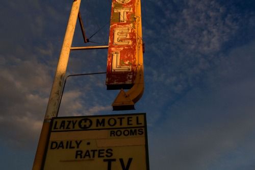 a motel sign with the sky in the background