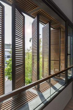 an open window with wooden slats on the outside and wood blinds on the inside