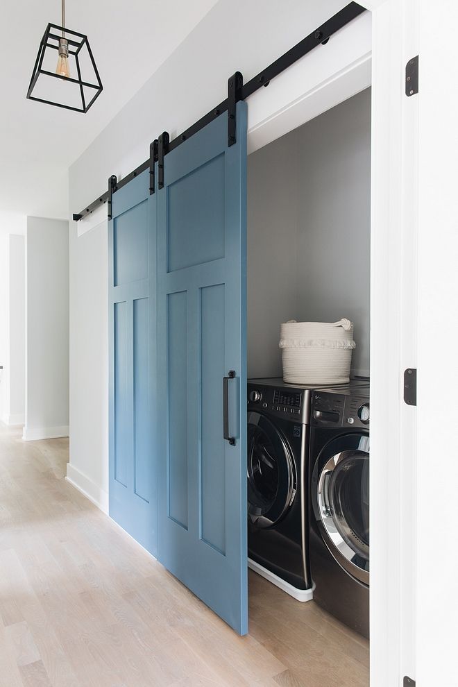 a blue door is open to reveal a washer and dryer in the room