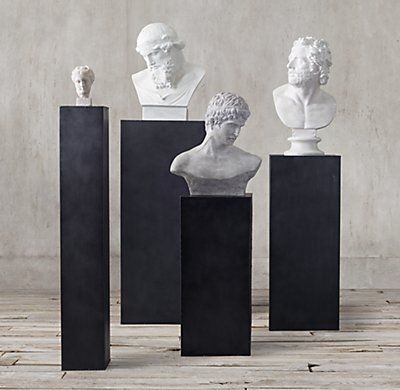 four marble busturines are lined up on pedestals