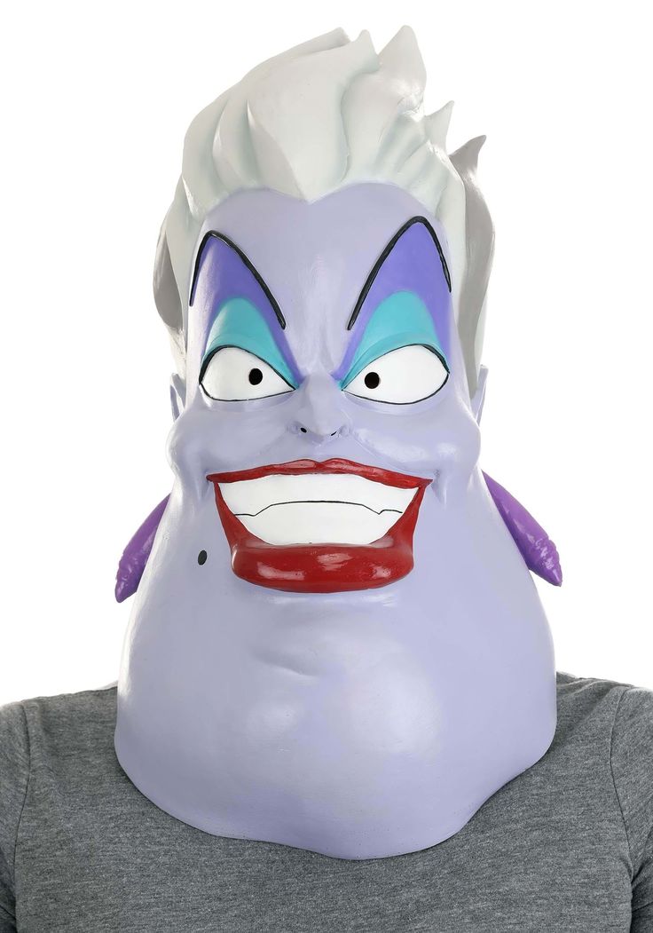 an adult wearing a purple dragon mask with blue eyes and red nose, while standing in front of a white background