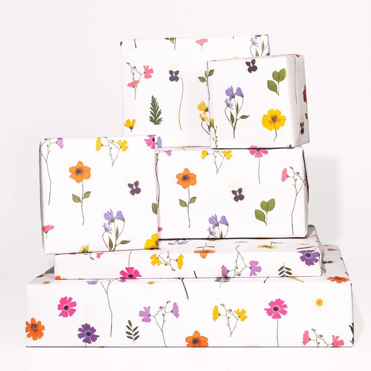 three boxes with flowers on them stacked next to each other in front of a white background